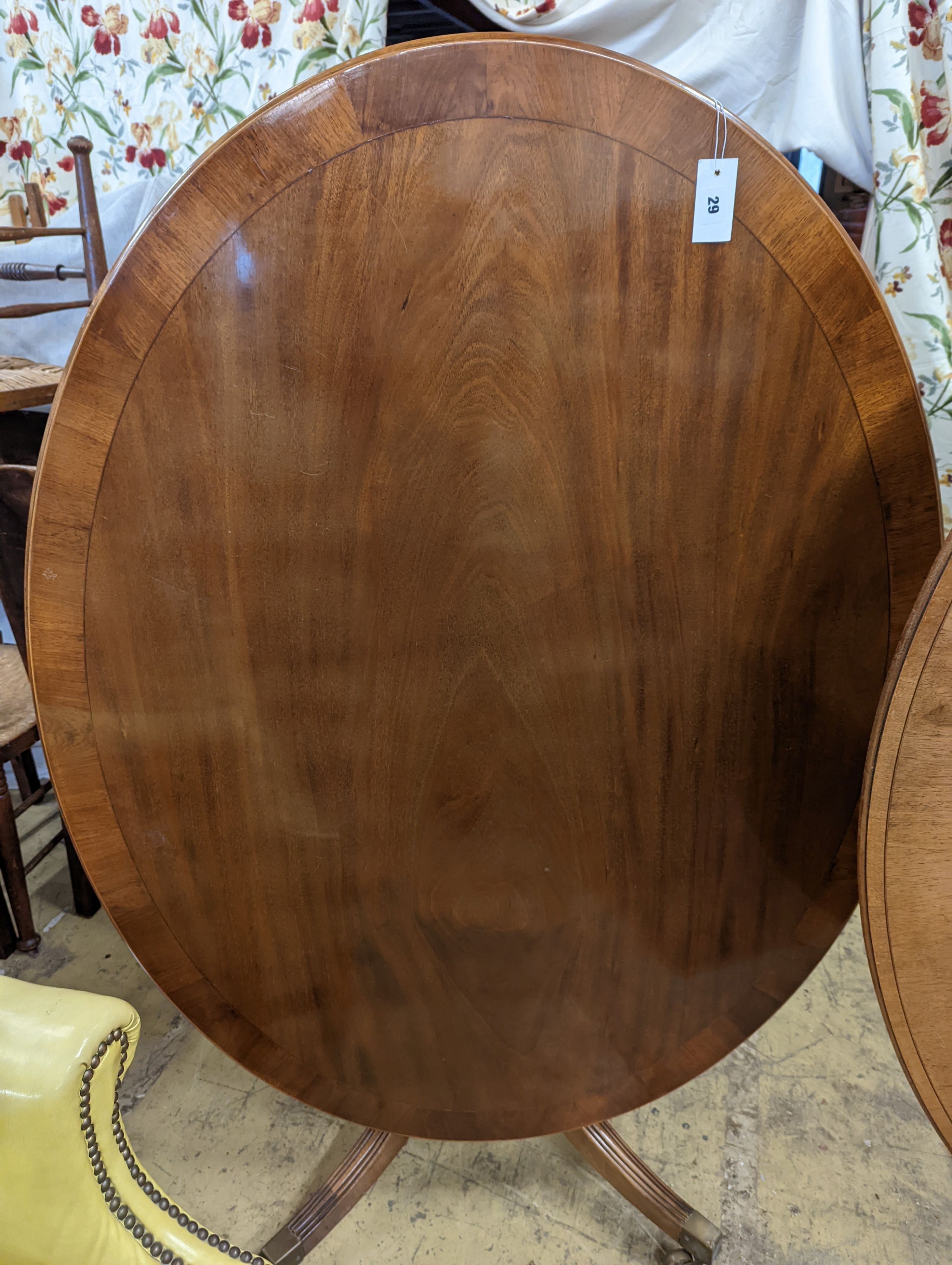 Attributed to William Tillman. A reproduction George III style oval mahogany pedestal tilt top dining table, width 105cm, length 135cm, height 72cm